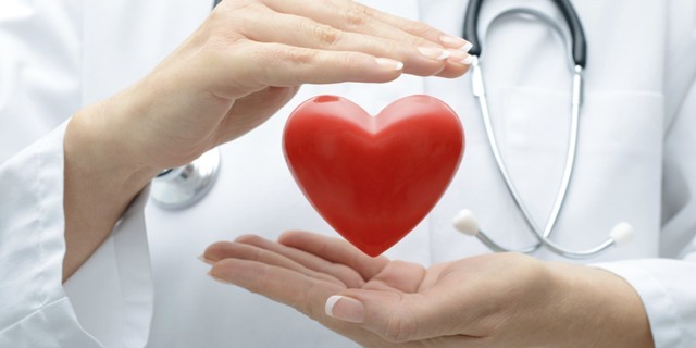 γιατρός κρατάει μία καρδιά υποδηλώνοντας την χοληστερίνη