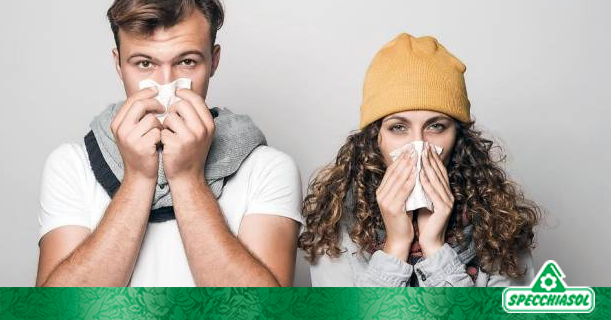 Ένας άντρας και μία γυναίκα με γρίπη κοιτάζουν την κάμερα ενώ φυσούν τις μύτες τους σε χαρτομάντηλα